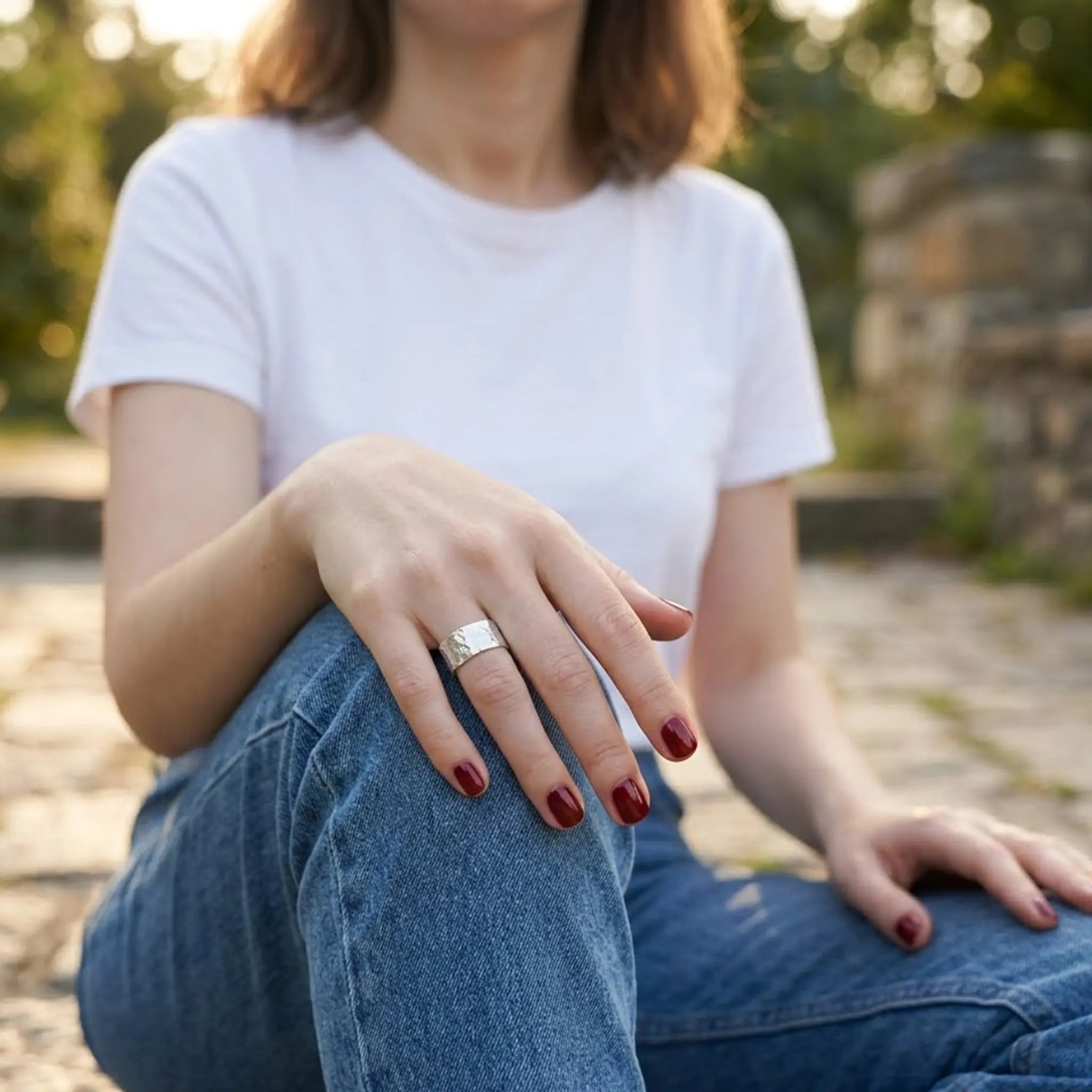 Hochwertiger Bandring Silber gehämmert im Freien getragen zu Jeans und weißem T-Shirt.
