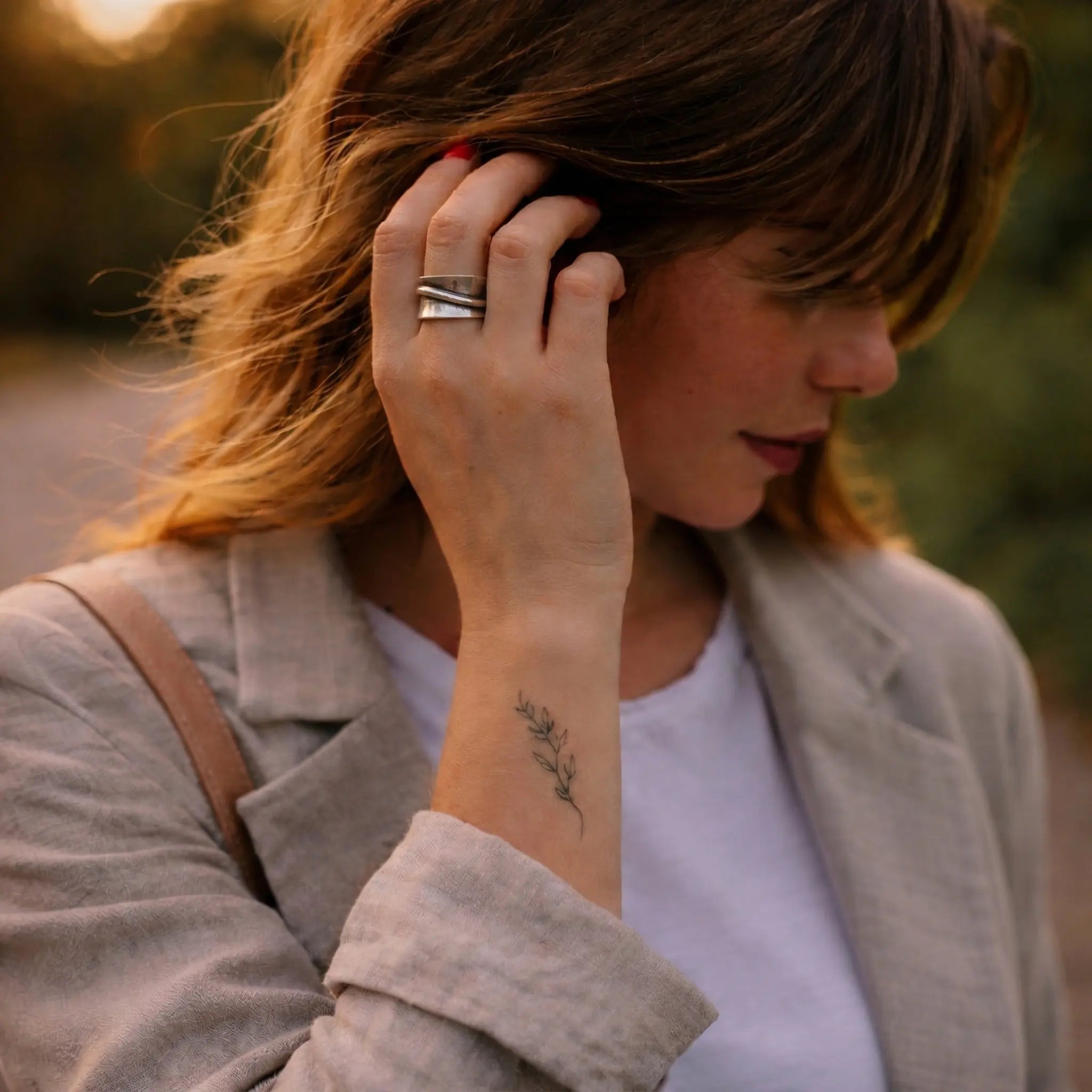Verstellbarer Statement Ring aus 925 Sterling Silber, breiter Damenring mit modernem silbernem Design, getragen von Frau im warmen Abendlicht mit beigem Blazer