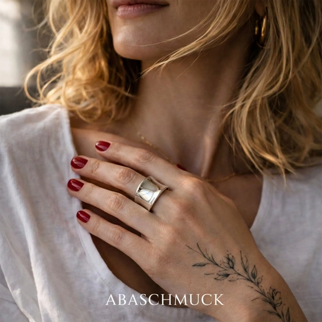 Eleganter breiter Silberring aus 925 Sterling Silber, verstellbarer Damenring an der Hand einer blonden Frau mit botanischem Tattoo, stilvoller Statement Ring im Lifestyle Foto
