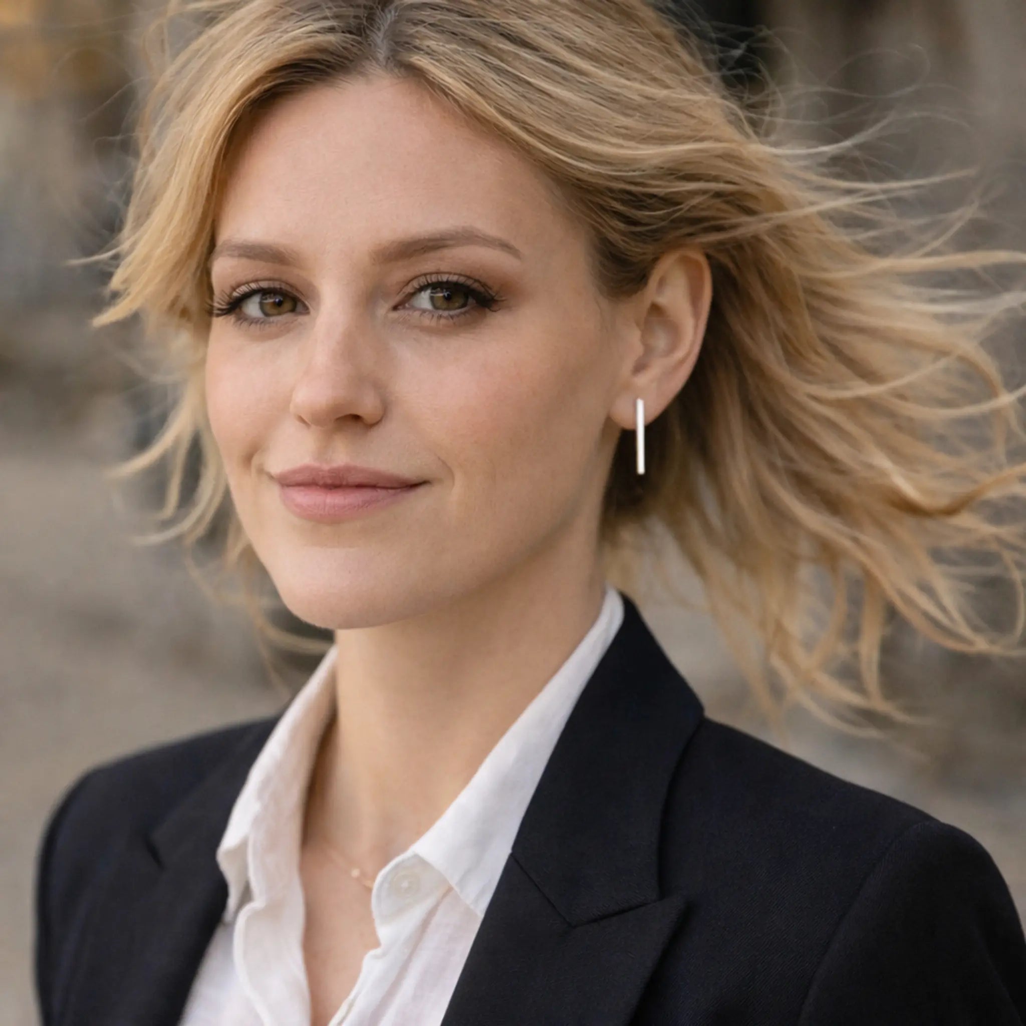 Blonde Frau mit langen minimalistischen Silberohrringen aus 925 Sterling Silber, eleganter Ohrschmuck im Business Look mit schwarzem Blazer und weißer Bluse