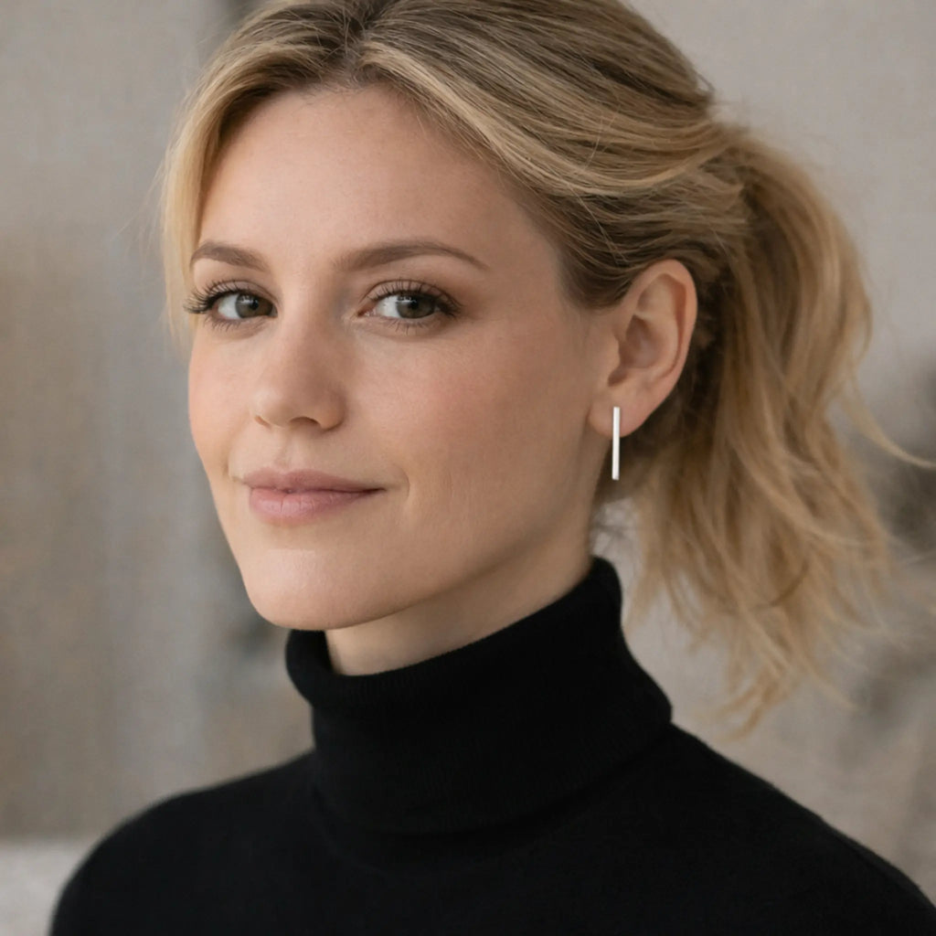 Elegante lange Silberohrringe aus 925 Sterling Silber, minimalistischer Damen Ohrschmuck im modernen Design, getragen von blonder Frau mit schwarzem Rollkragen