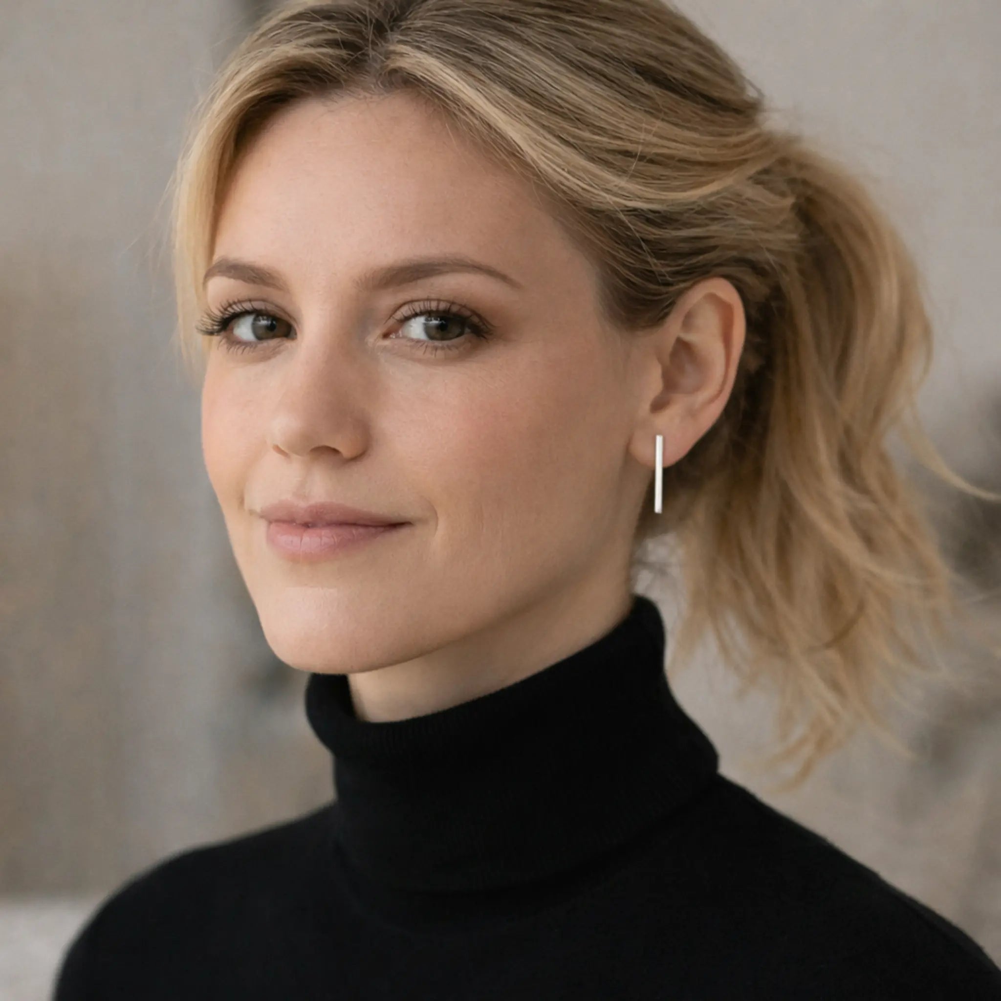Elegante lange Silberohrringe aus 925 Sterling Silber, minimalistischer Damen Ohrschmuck im modernen Design, getragen von blonder Frau mit schwarzem Rollkragen