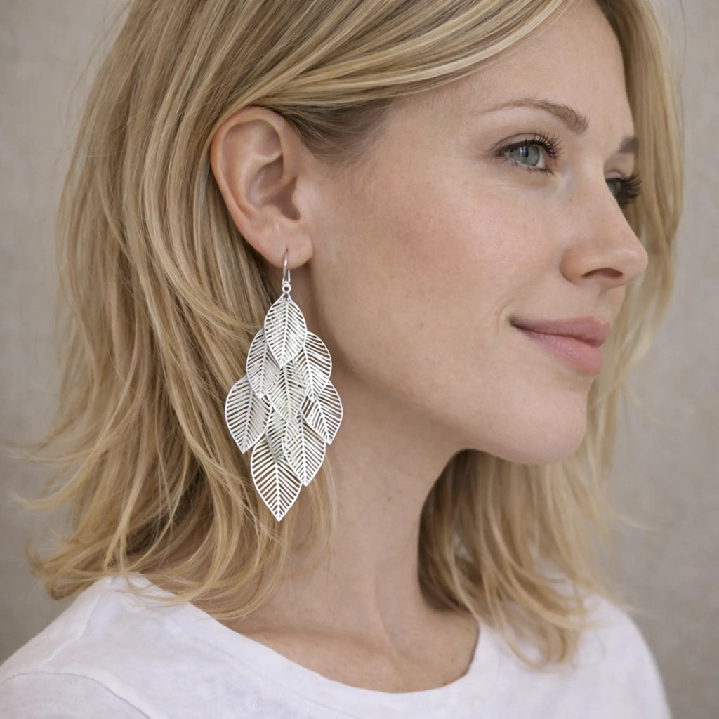 Frau trägt lange filigrane Blatt-Ohrringe aus 925 Sterling Silber – große, glänzende Hängeohrringe im Boho-Look, nickelfrei.