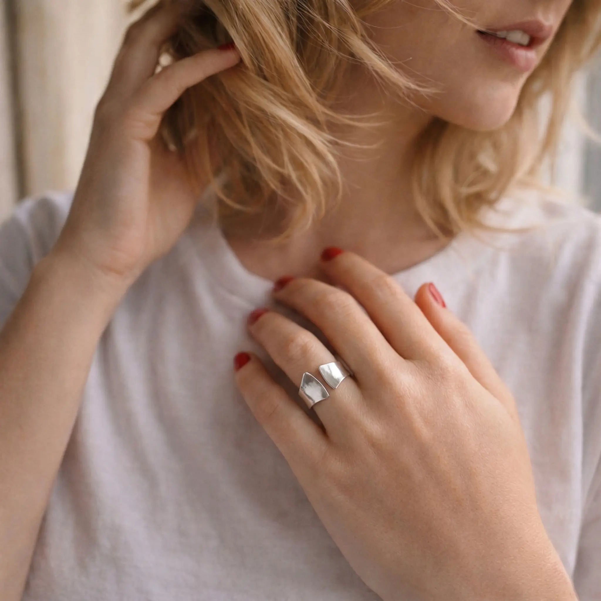 Eleganter Damenring aus 925 Sterling Silber mit offenem geometrischem Design, verstellbarer Silberring an der Hand einer blonden Frau im stilvollen Lifestyle Foto