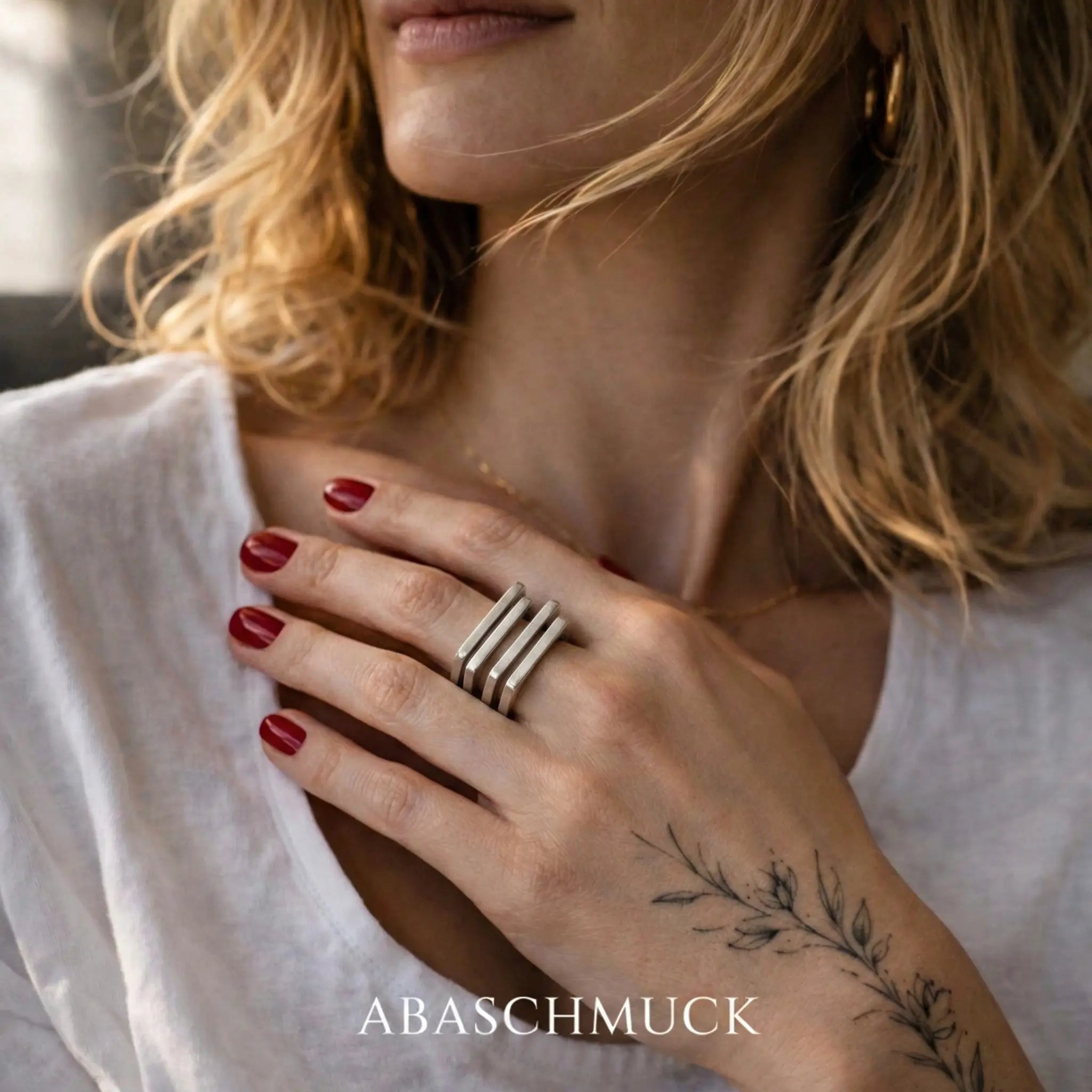Eleganter Damenring aus 925 Sterling Silber mit offenem geometrischem Design, verstellbarer Silberring an der Hand einer blonden Frau im hellen natürlichen Portrait