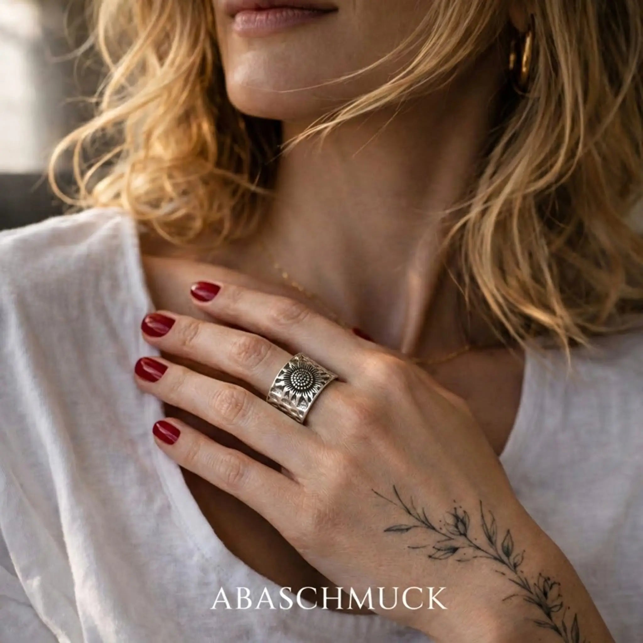 Breiter Silberring 925 Sterling Silber mit Sonnenblume Motiv an der Hand einer Frau mit Tattoo von ABASCHMUCK.
