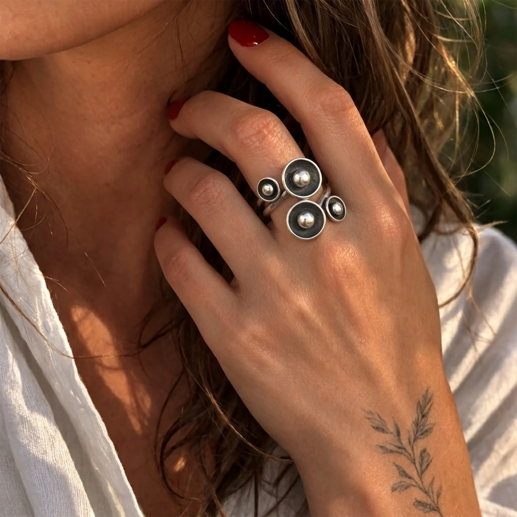 Großer Silberring 925 mit modernem Kreise und Kugeln Design, eleganter Damenring an der Hand einer Frau mit weißer Bluse im warmen Abendlicht
