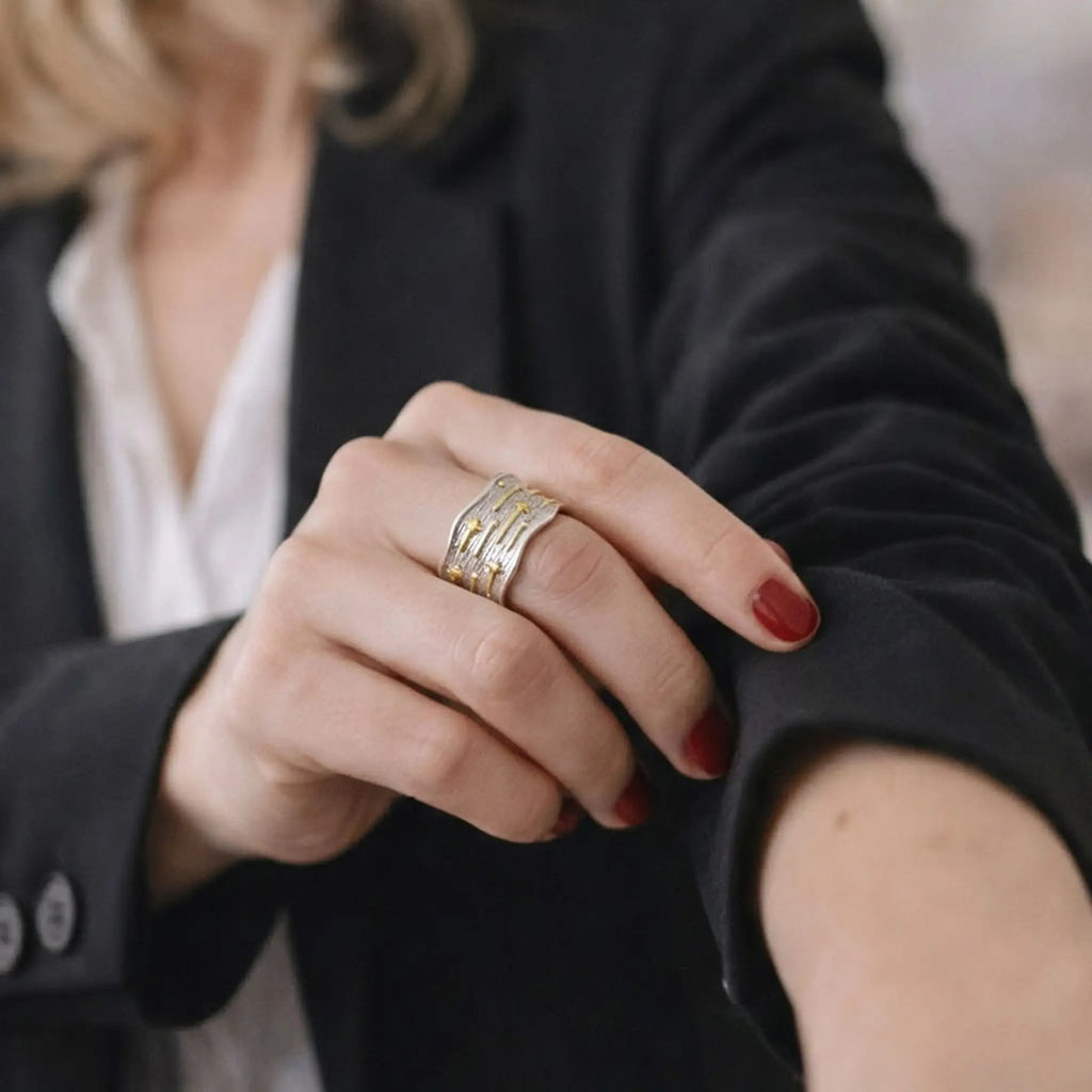 Eleganter Design-Ring Silber Gold strukturiert getragen zum schwarzen Business-Blazer.