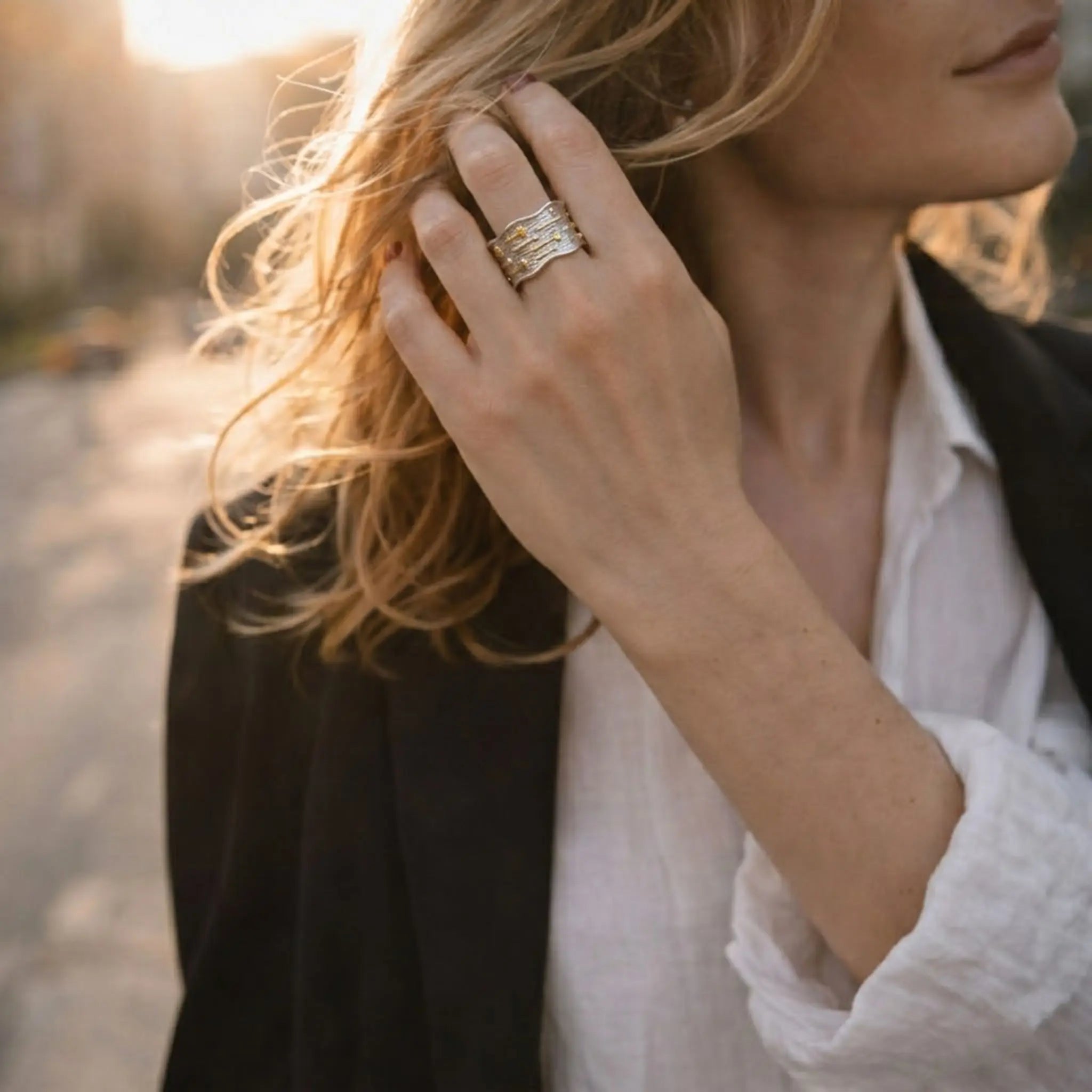 Hochwertiger Statement-Schmuck: Breiter zweifarbiger Ring im Gegenlicht der Sonne.