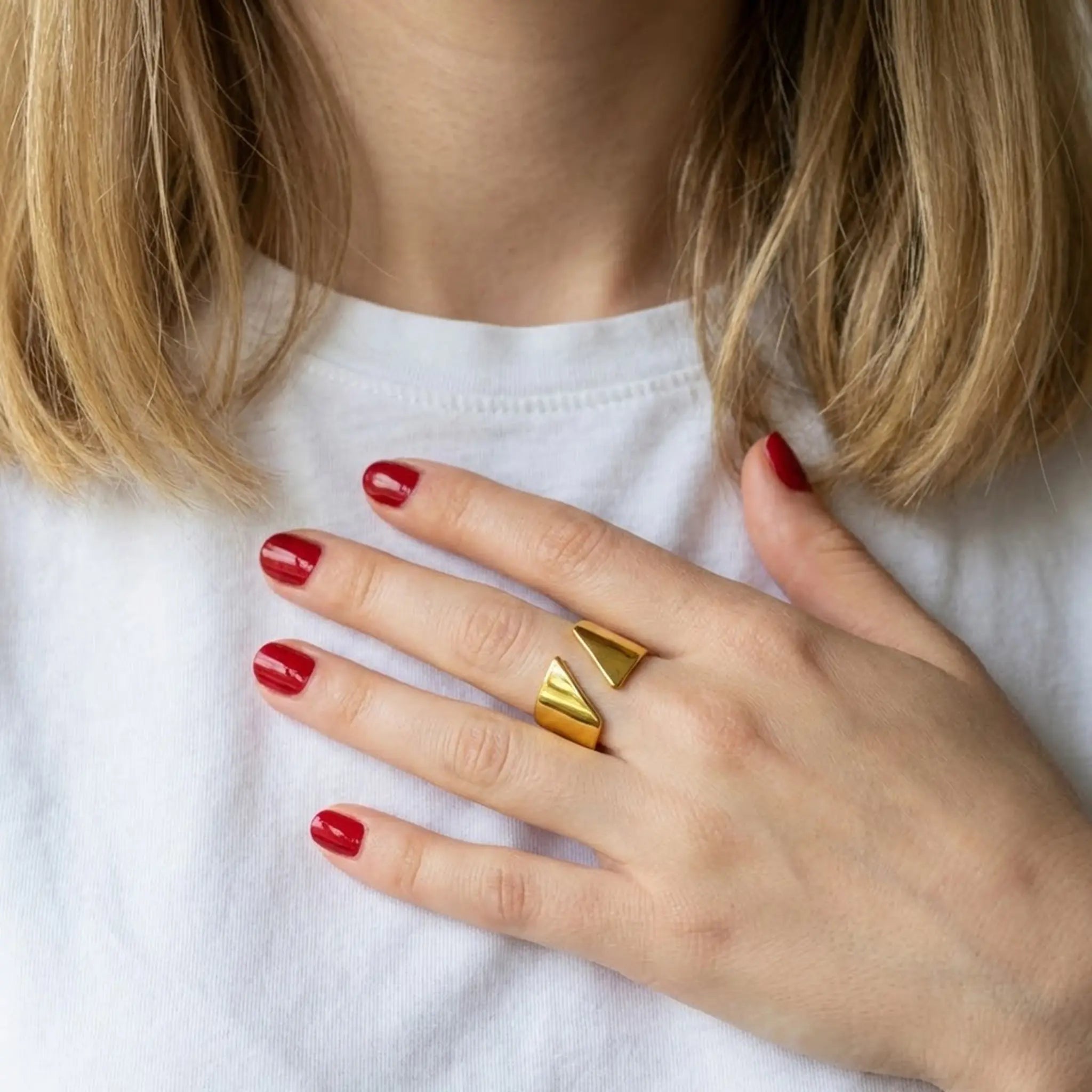 Vergoldeter verstellbarer Silberring 925 mit geometrischem Design am Finger getragen zu weißem Shirt und rotem Nagellack