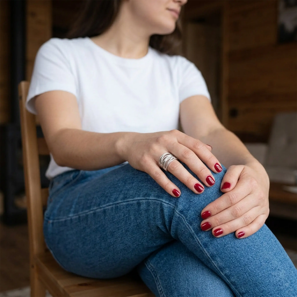 Sitzende Frau in Jeans und weißem T-Shirt – verstellbarer Silberring 925 als Bandring offen, alltagstauglich