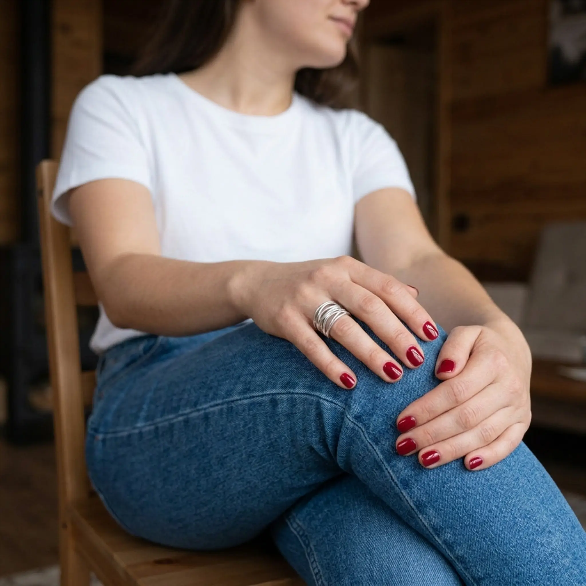 Sitzende Frau in Jeans und weißem T-Shirt – verstellbarer Silberring 925 als Bandring offen, alltagstauglich