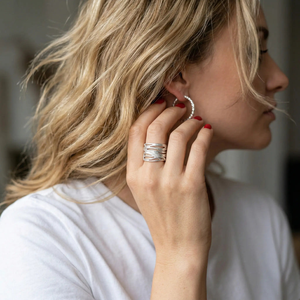 Frau greift an Ohrring – 925 Silber Wickelring/ Bandring offen, rote Nägel, moderner clean Chic