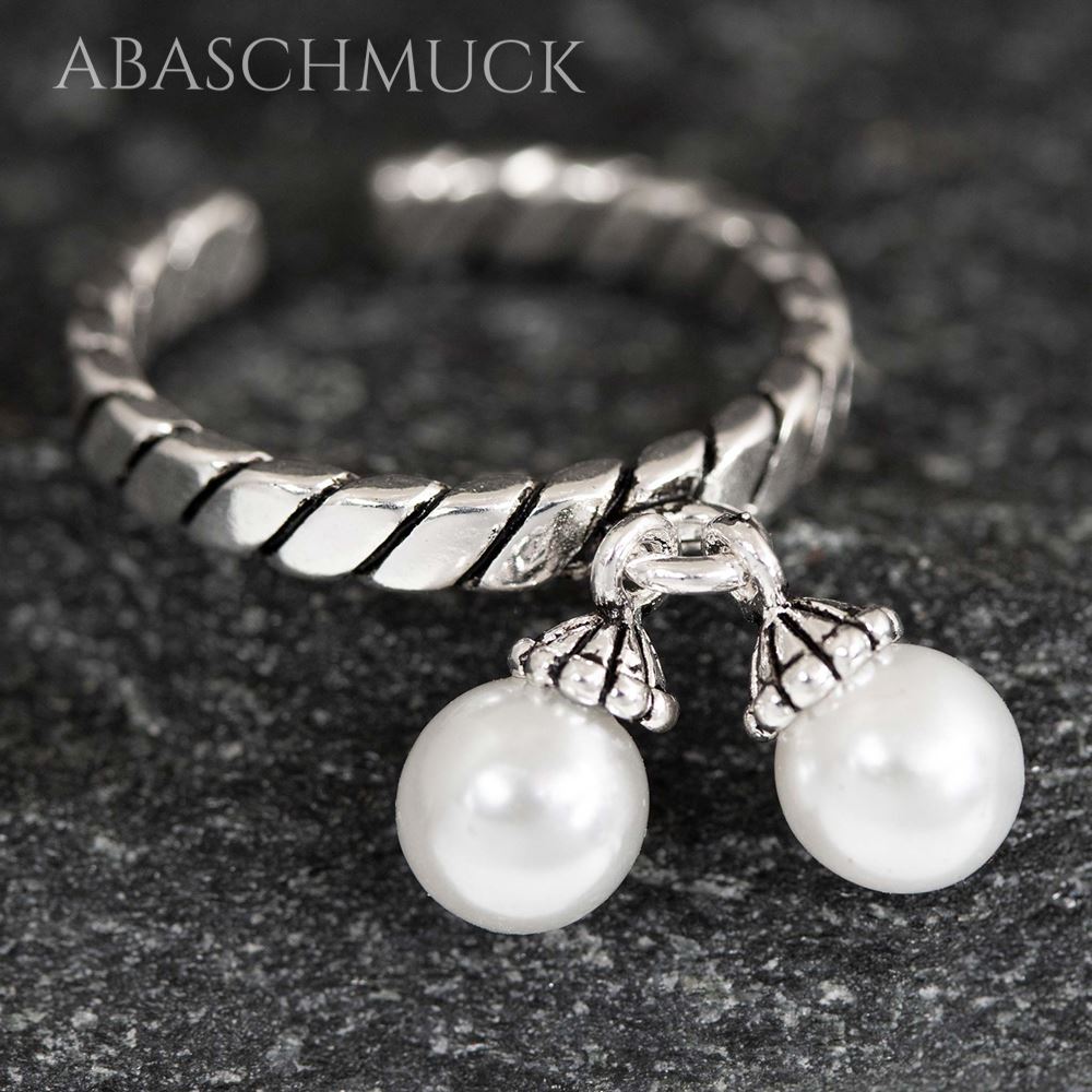 Frontansicht eines offenen Silberrings mit schimmernden Perlenanhängern.