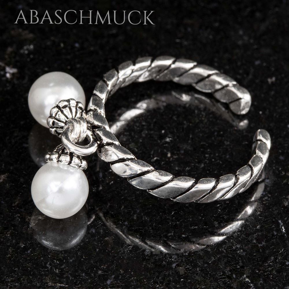 Detailfoto eines offenen Rings mit gedrehter Struktur und Perlenanhängern.