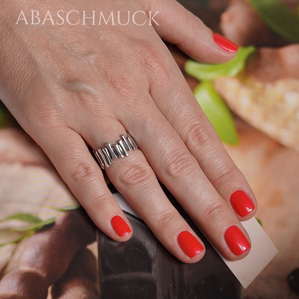 Offener Silberring 925 am Finger einer Frau, stilvoll kombiniert in Alltagsszene.