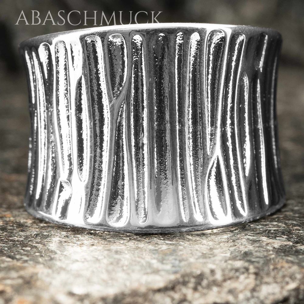 Nahaufnahme eines breiten Silberrings 925 mit strukturierter, organischer Oberfläche.
