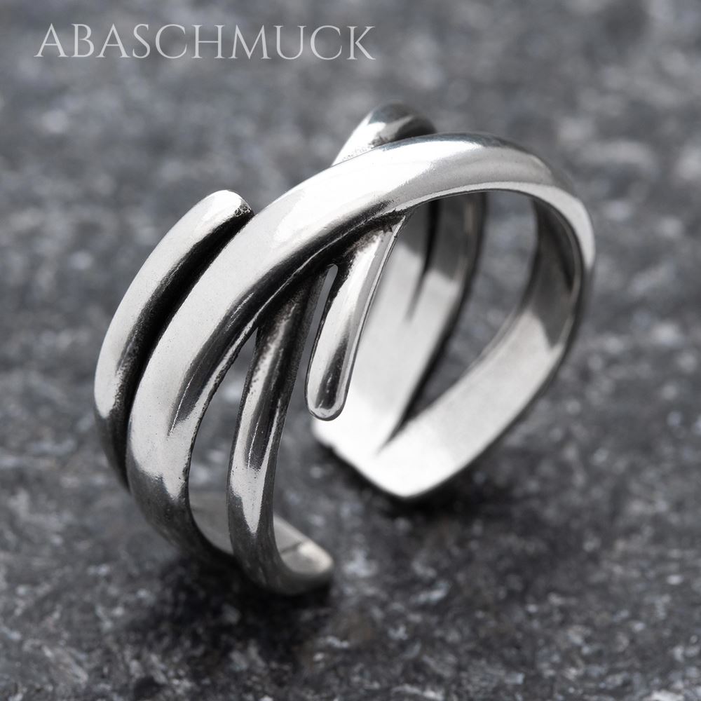 Nahaufnahme eines geschwungenen offenen Silberrings 925 auf dunkler Steinoberfläche.