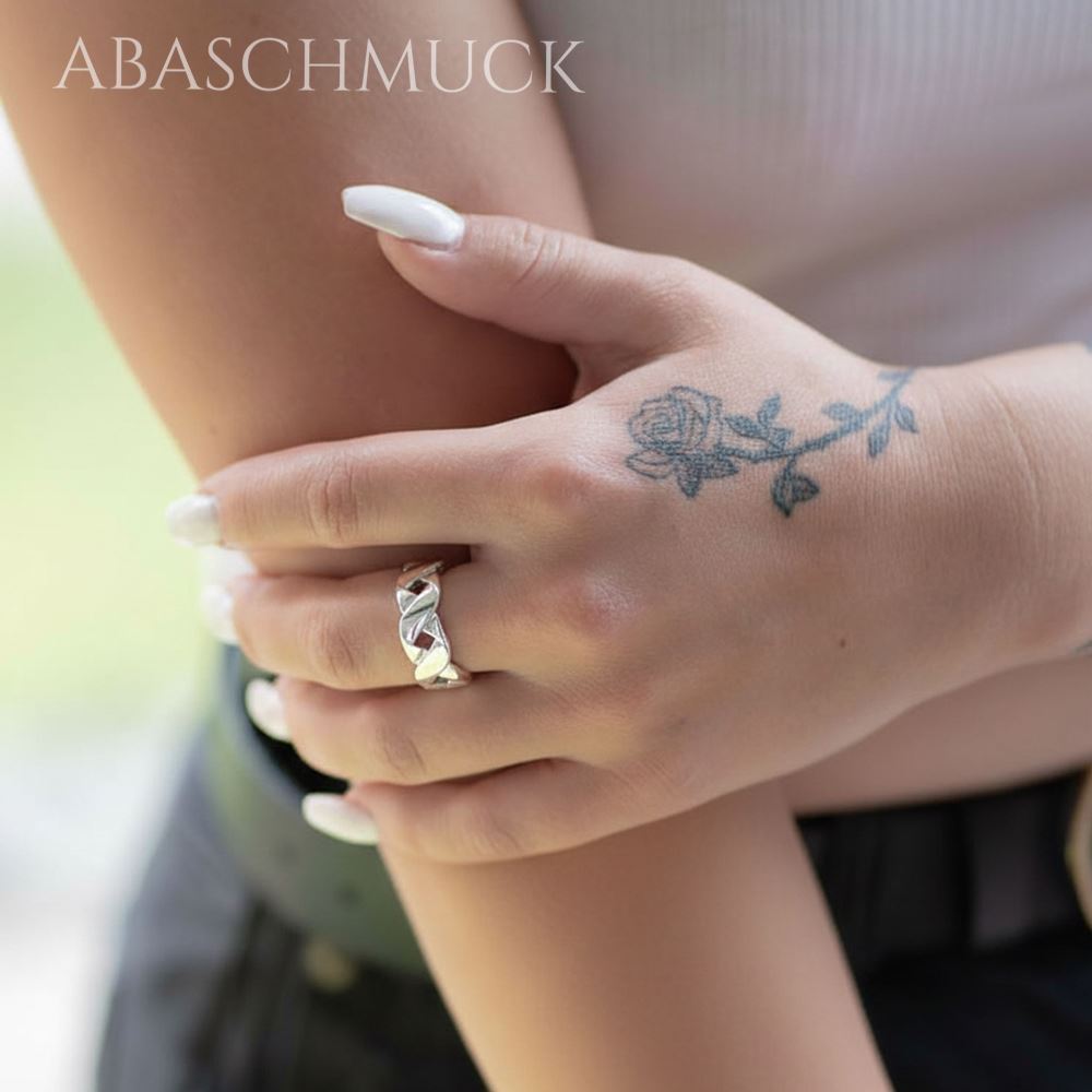 Handaufnahme mit glänzendem geflochtenem Silberring 925 am Finger einer Frau.