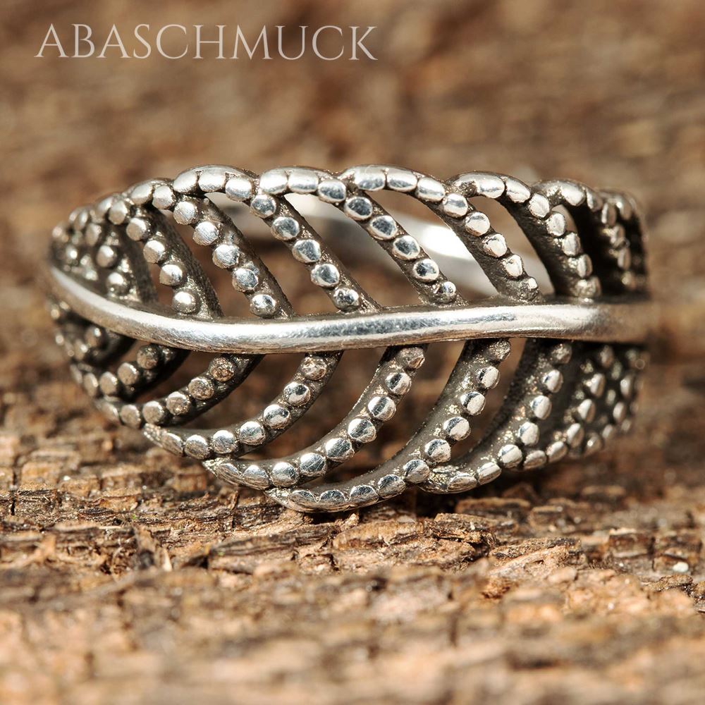 Nahaufnahme eines filigranen Silberrings 925 im Blattdesign auf Holzstruktur.