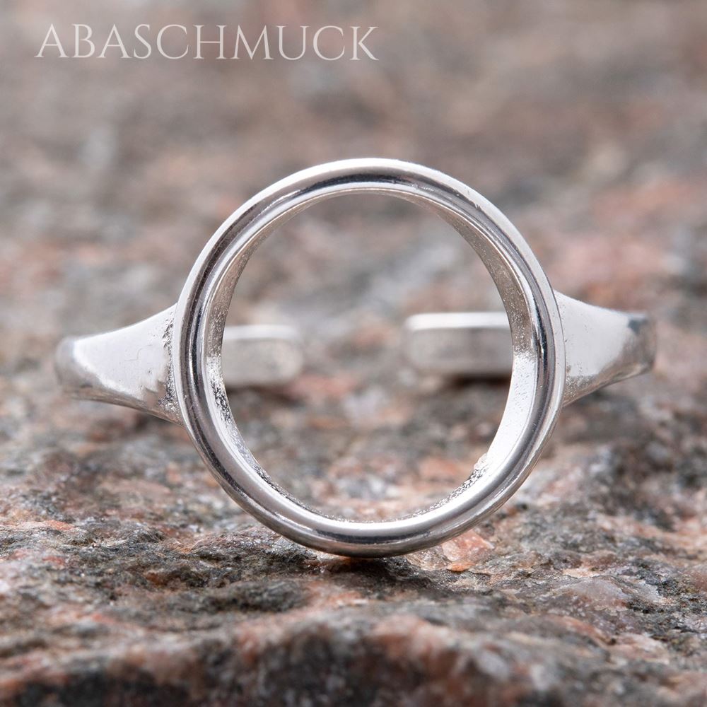 Offener 925-Silberring mit kreisförmigem Ringkopf, frontal auf einer rötlich-grauen Steinstruktur aufgenommen.