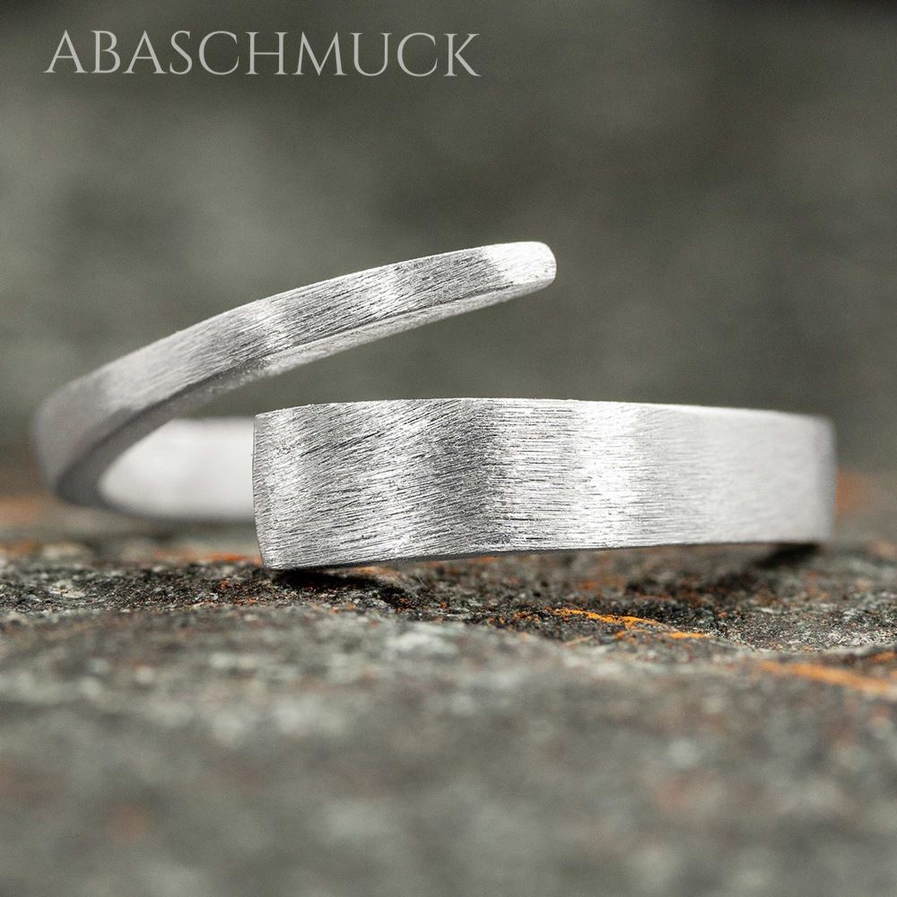 Moderner 925-Silberring mit gebürsteter Oberfläche, seitlich auf Stein fotografiert.