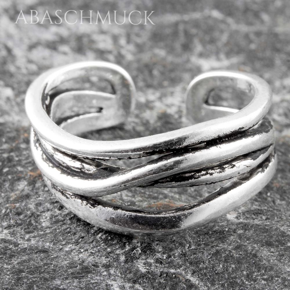 Silberring mit geschwungenen Linien in Nahaufnahme auf grauem Stein.