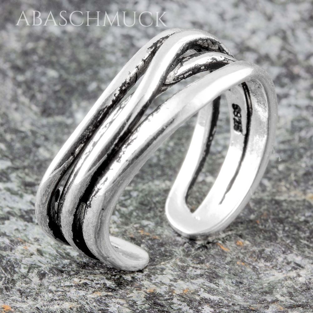 Verstellbarer Silberring mit mehreren übereinanderliegenden Bändern auf Steinfläche.