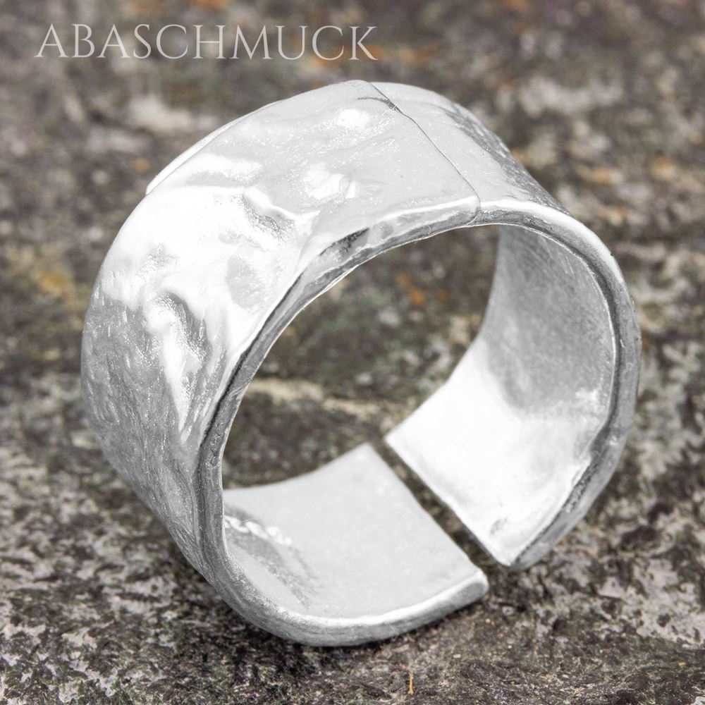 Strukturierter breiter Silberring mit offener Rückseite auf Stein.