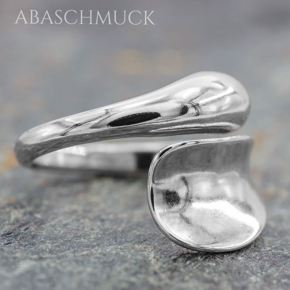 Eleganter Silberring mit zwei organisch geformten Enden auf strukturiertem Hintergrund
