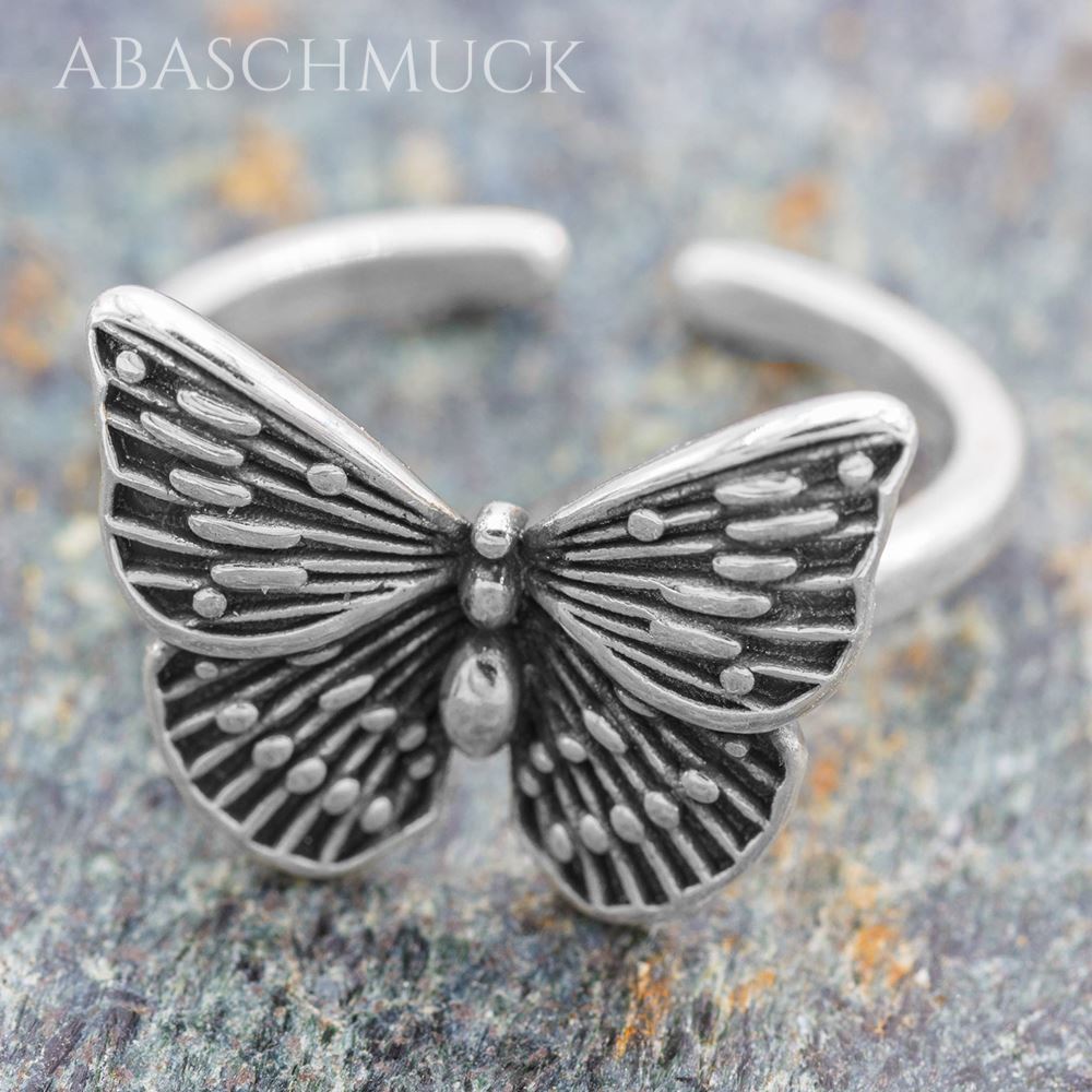 Verstellbarer Bandring mit Schmetterling auf leichtem Steinuntergrund