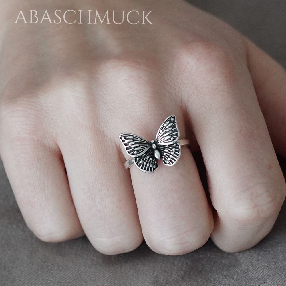 Schmetterling-Silberring an der Hand, elegant und feminin präsentiert
