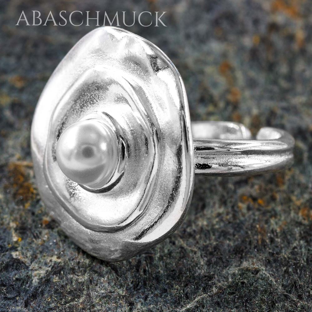 Femininer Silberring mit Perle und organischer Form auf strukturiertem Stein