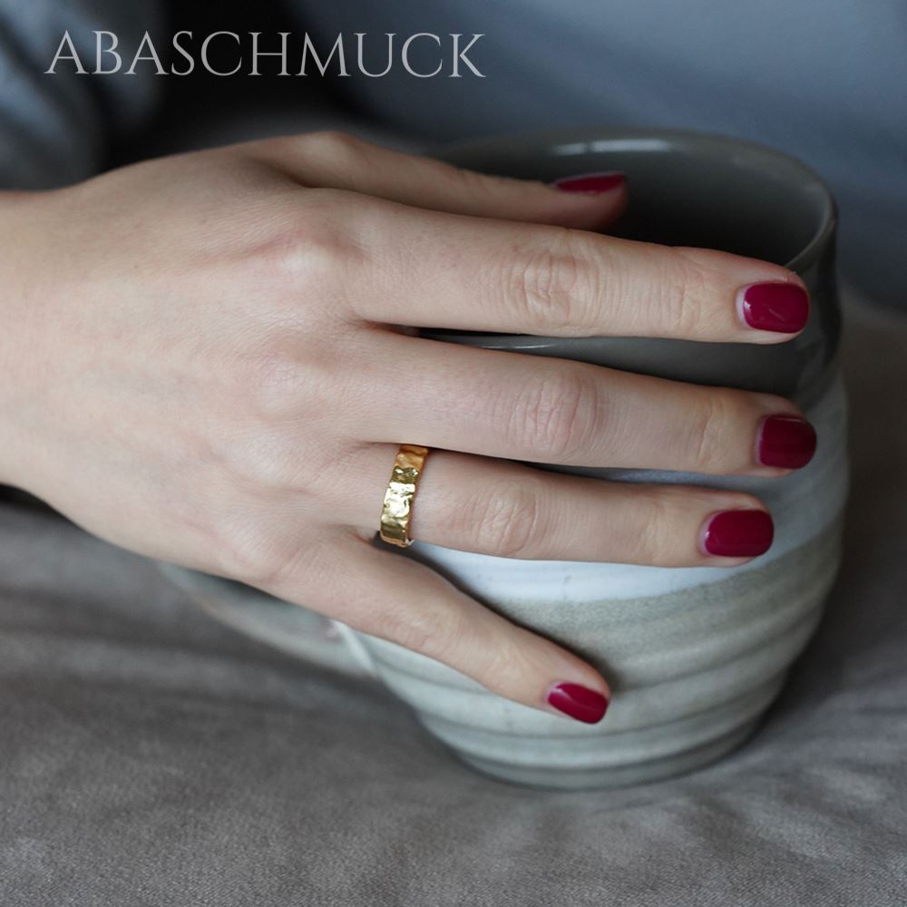 Ring mit strukturierter Oberfläche in Goldoptik an weiblicher Hand