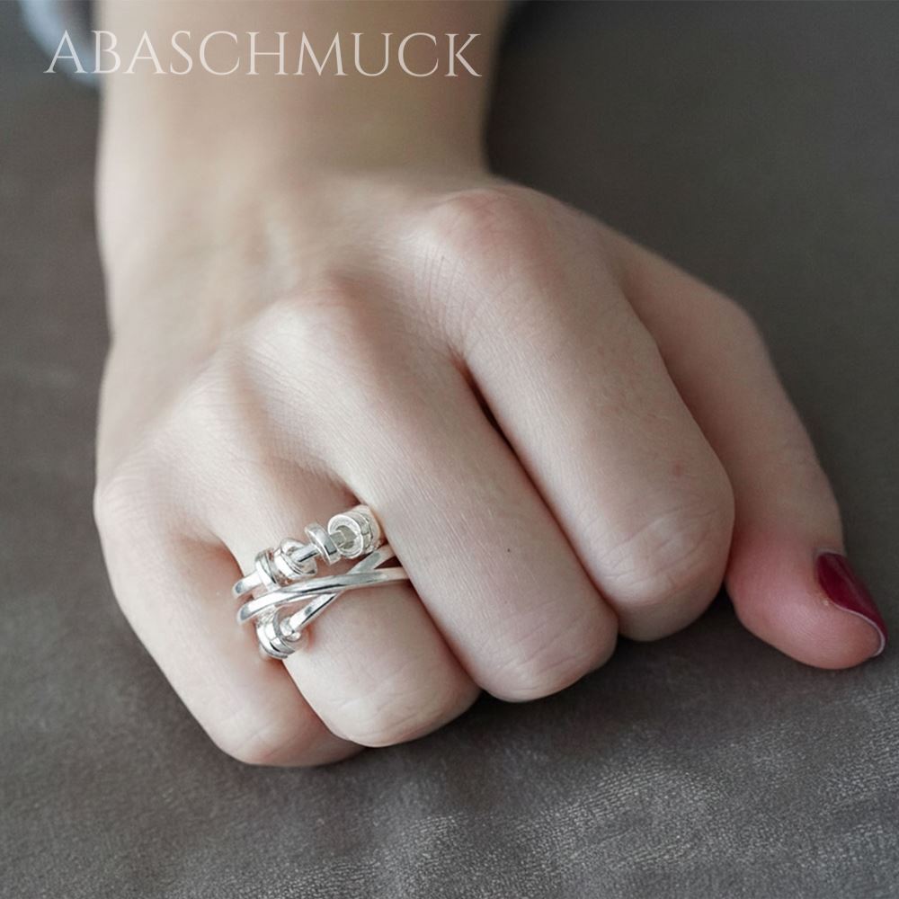 Hand mit modernem verstellbarem Silberring 925 mit überkreuzten Streben.