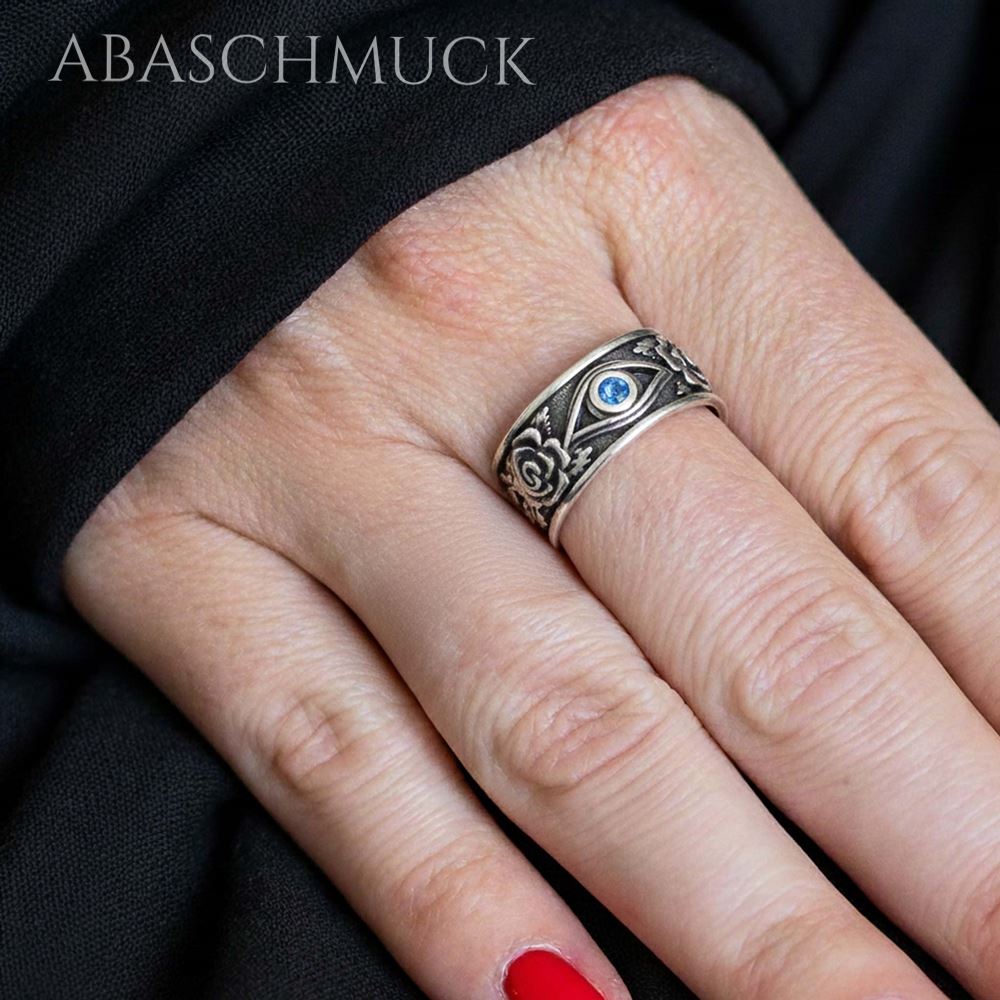 Verstellbarer Rosen-Silberring mit blauem Stein, an der Hand getragen.
