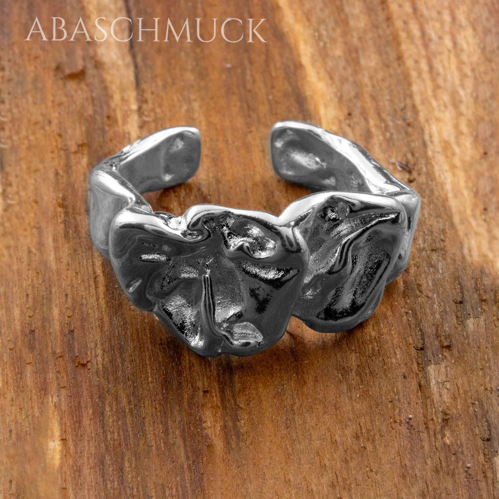 Offener Sterling-Silberring mit plastischer Oberfläche auf Holzuntergrund.