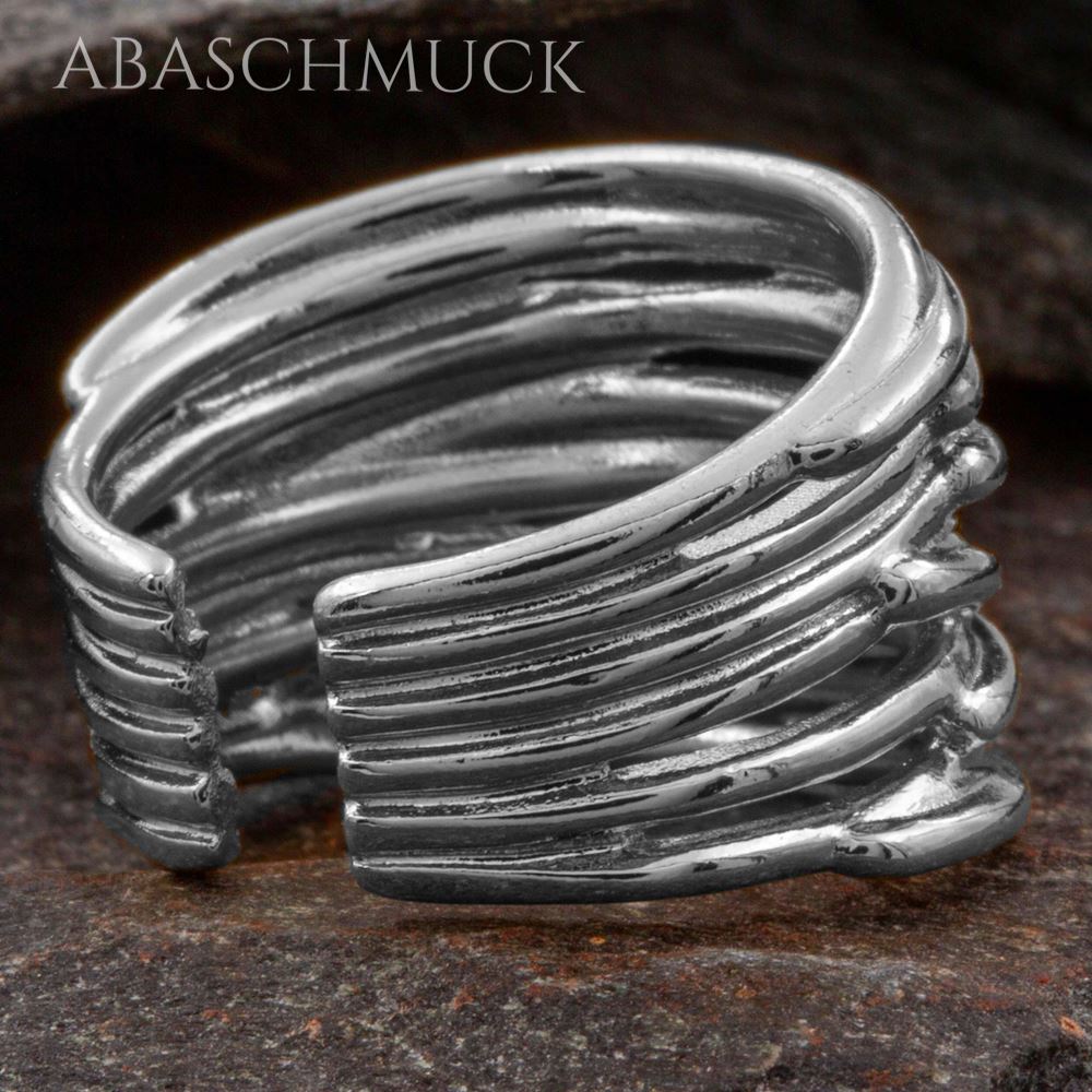 Moderner Silberring 925 mit mehrfachen Linien, fotografiert auf dunklem Stein.