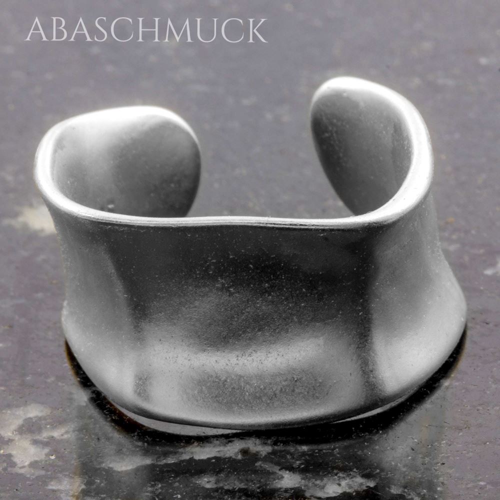 Breiter, matter Silberring 925 im offenen Design auf dunkler Steinfläche.